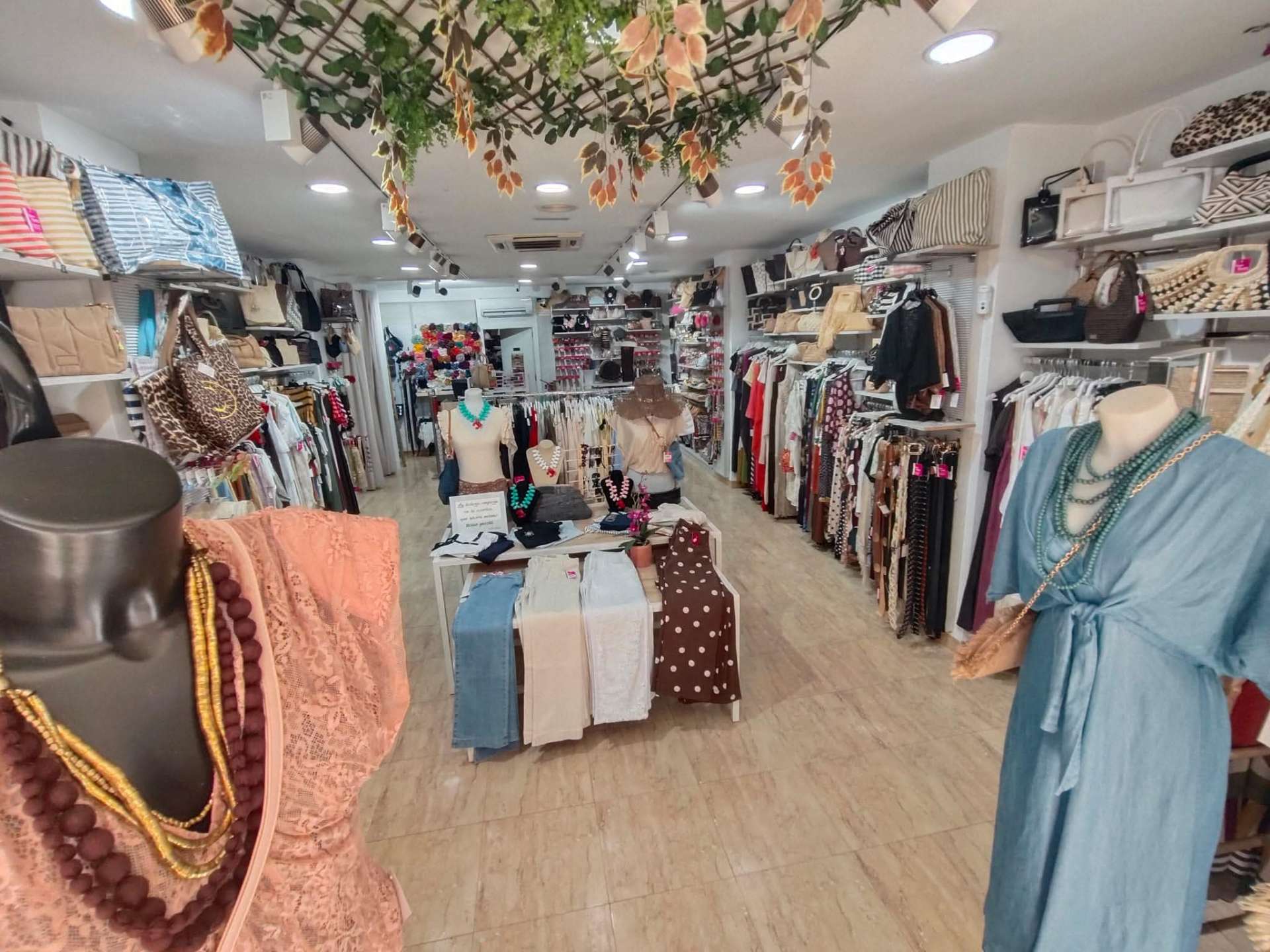 Vista interior con bolsos, vestidos y maniquíes en Rosa Baena Complementos